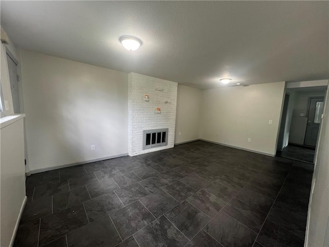 unfurnished living room with a brick fireplace and baseboards