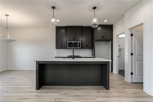 16502 S Stagecoach St, Olathe, KS 66062 - kitchen with stainless steel microwave, light countertops, backsplash, baseboards, and recessed lighting