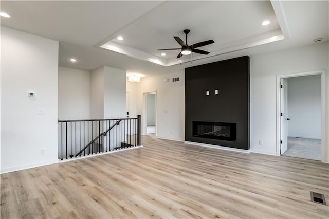 16502 S Stagecoach St, Olathe, KS 66062 - unfurnished living room featuring a raised ceiling, light wood finished floors, recessed lighting, ceiling fan, and baseboards