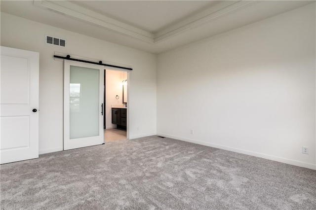 16502 S Stagecoach St, Olathe, KS 66062 - unfurnished bedroom with a barn door, carpet, a raised ceiling, ornamental molding, and baseboards