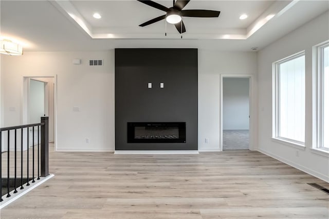 16502 S Stagecoach St, Olathe, KS 66062 - unfurnished living room featuring a tray ceiling, a ceiling fan, light wood-style floors, and recessed lighting