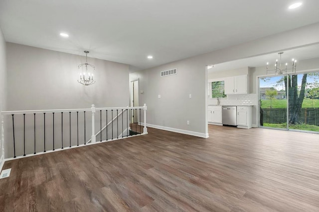 interior space featuring visible vents, recessed lighting, wood finished floors, and a chandelier
