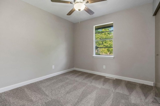 empty room with baseboards, carpet, ceiling fan, and visible vents