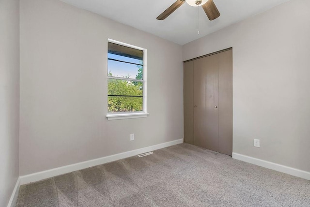 unfurnished bedroom featuring baseboards, visible vents, carpet, and a closet