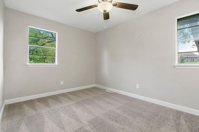 empty room with baseboards, ceiling fan, and carpet