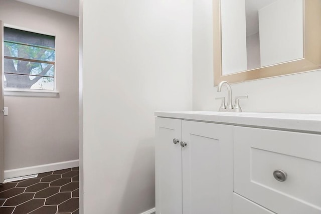 bathroom featuring baseboards, tile patterned flooring, and vanity