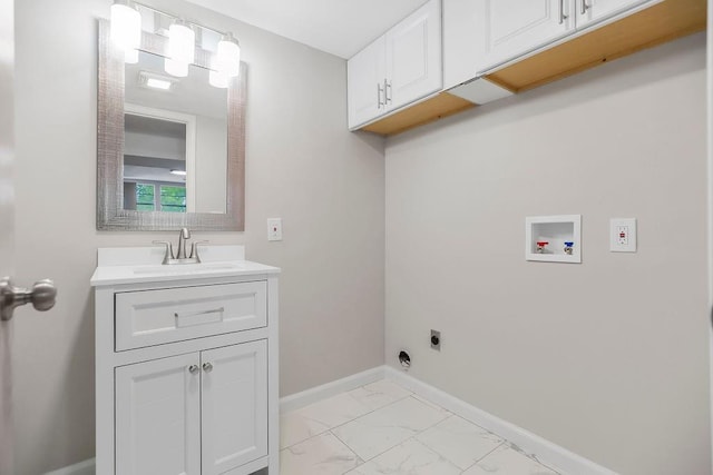 laundry area featuring marble finish floor, baseboards, cabinet space, a sink, and washer hookup