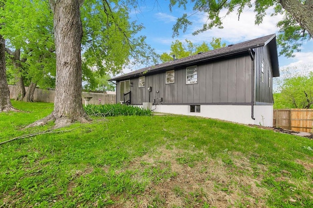 back of property featuring a fenced backyard and a yard