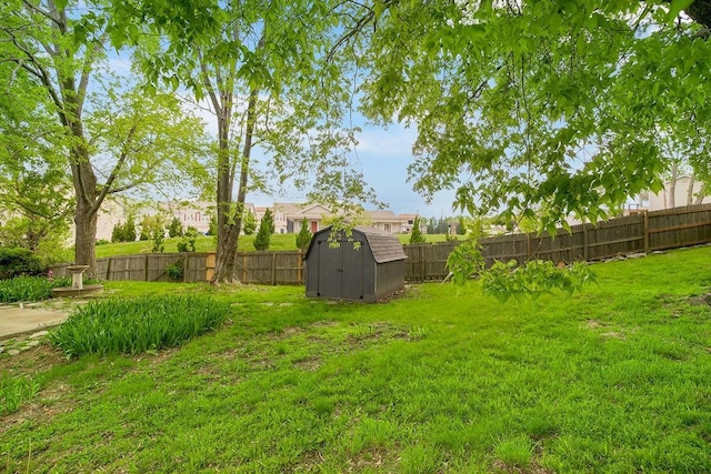 view of yard with a storage shed, an outbuilding, and a fenced backyard