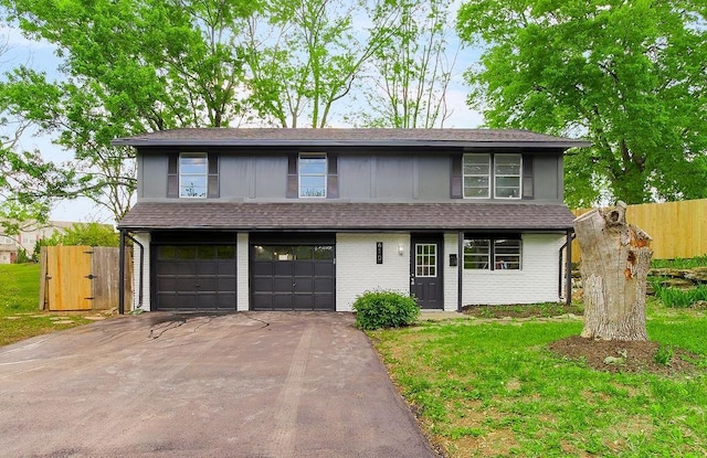 view of front of property with fence, brick siding, a garage, a front yard, and concrete driveway