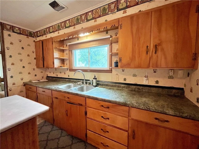 kitchen featuring brown cabinets, open shelves, wallpapered walls, and a sink