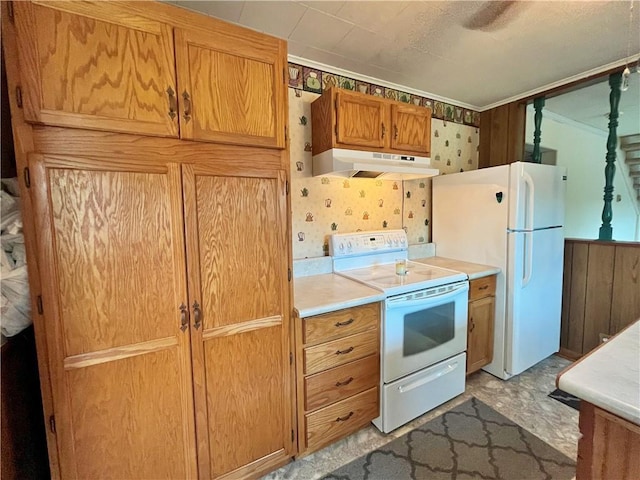 kitchen with ornamental molding, white appliances, light countertops, under cabinet range hood, and brown cabinets