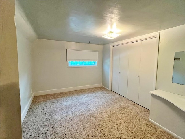 unfurnished bedroom featuring carpet flooring, baseboards, and a closet