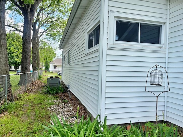 view of property exterior with fence and central air condition unit