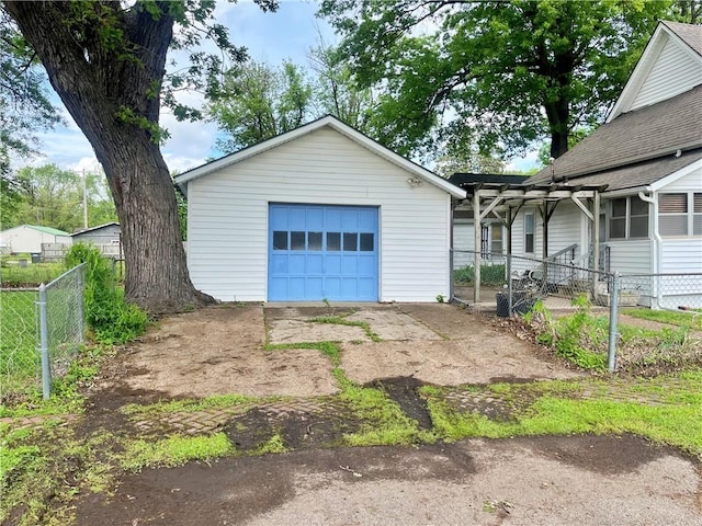 exterior space with an outdoor structure, a garage, fence, and driveway