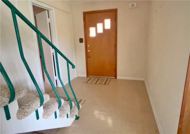 foyer entrance with baseboards and stairs