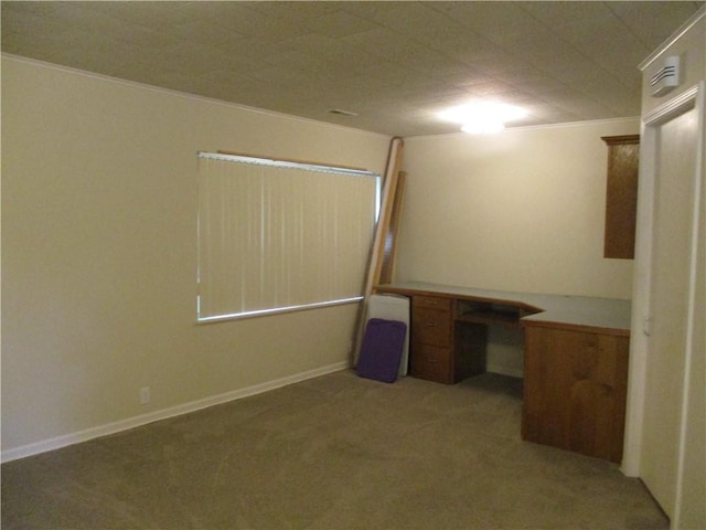 interior space featuring carpet floors, ornamental molding, and built in study area