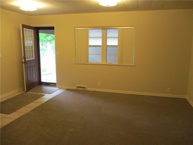 carpeted entrance foyer with baseboards, ornamental molding, and visible vents