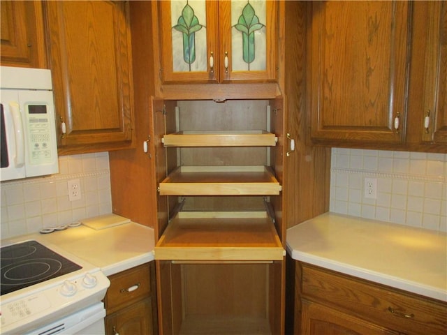 kitchen featuring light countertops, brown cabinets, tasteful backsplash, and white appliances