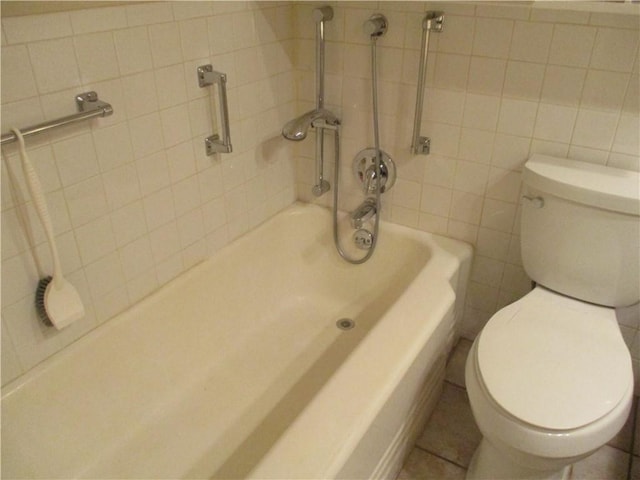 full bath with a bathtub, toilet, and tile walls