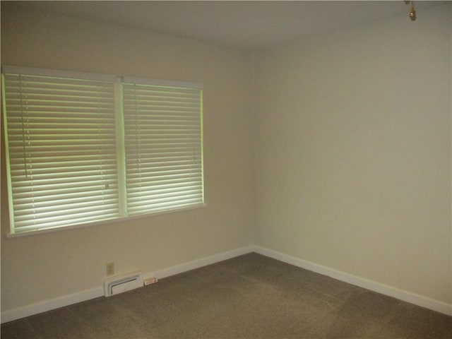 carpeted spare room with baseboards and visible vents