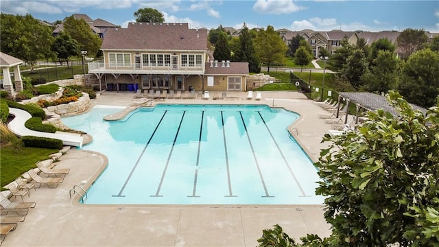 community pool with fence and a patio
