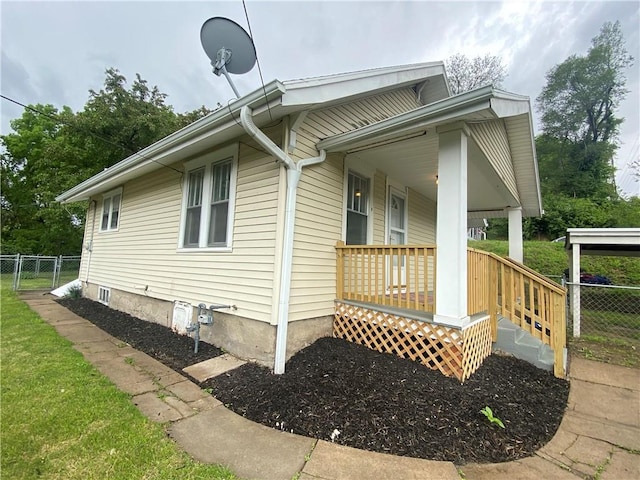 view of side of property with covered porch and fence