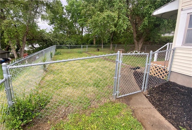 view of yard with a fenced backyard and a gate