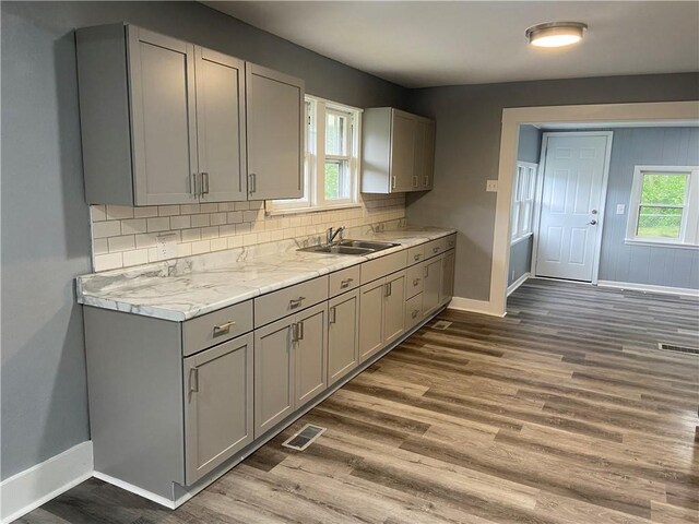 kitchen featuring a sink, baseboards, gray cabinetry, and visible vents