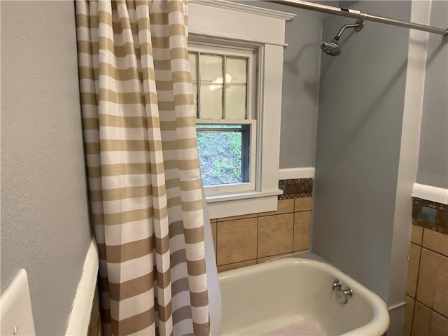 bathroom featuring a tub to relax in and a shower with curtain