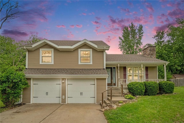 15 Baber Cir, Camden Point, MO 64018 - tri-level home featuring an attached garage, covered porch, a chimney, a lawn, and concrete driveway
