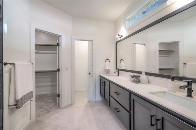 16567 S Stagecoach St, Olathe, KS 66062 - full bathroom featuring a walk in closet, double vanity, tile patterned floors, and baseboards