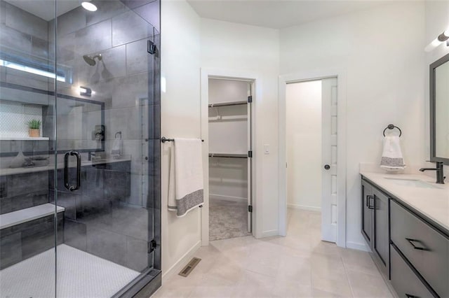 16567 S Stagecoach St, Olathe, KS 66062 - bathroom featuring a shower stall, a walk in closet, vanity, tile patterned flooring, and baseboards