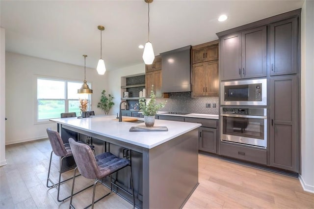 16567 S Stagecoach St, Olathe, KS 66062 - kitchen featuring appliances with stainless steel finishes, a kitchen breakfast bar, custom range hood, decorative backsplash, and light countertops