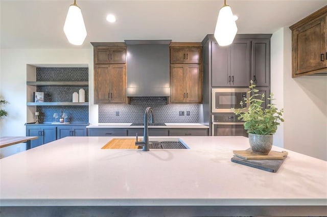 16567 S Stagecoach St, Olathe, KS 66062 - kitchen with stainless steel appliances, a sink, light countertops, decorative backsplash, and hanging light fixtures