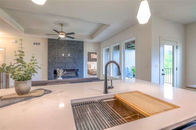16567 S Stagecoach St, Olathe, KS 66062 - living area featuring a raised ceiling, a fireplace, and a ceiling fan