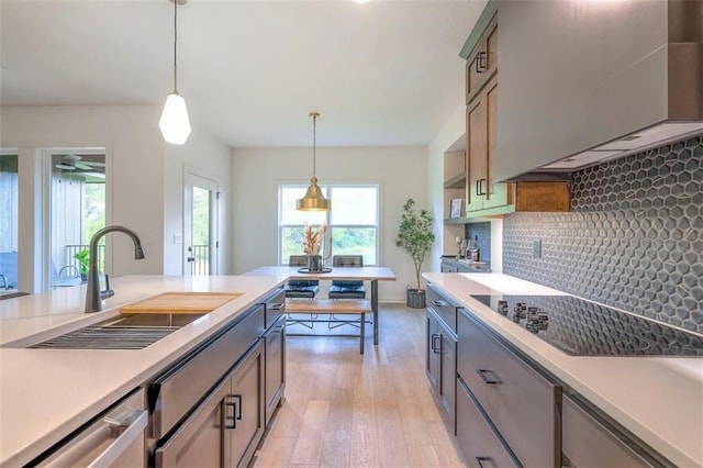 16567 S Stagecoach St, Olathe, KS 66062 - kitchen with a sink, hanging light fixtures, light wood finished floors, light countertops, and black electric stovetop