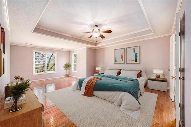 14475 Chadwick St, Leawood, KS 66224 - bedroom with light wood-style floors, baseboards, ornamental molding, and a tray ceiling