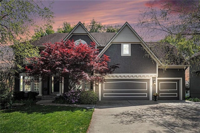 14475 Chadwick St, Leawood, KS 66224 - view of front of property with an attached garage, a front lawn, stucco siding, and driveway
