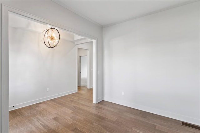 7015 Forest Lks, Parkville, MO 64152 - empty room featuring a chandelier, crown molding, wood finished floors, and baseboards
