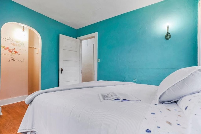 bedroom featuring baseboards and wood finished floors