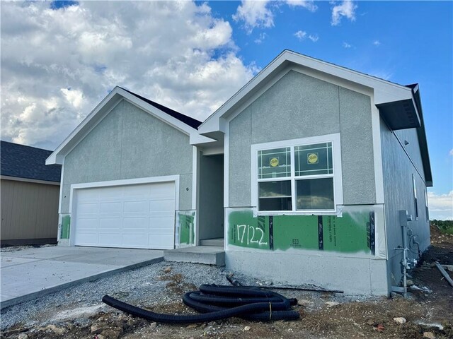 single story home featuring a garage, stucco siding, and concrete driveway