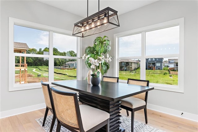 dining space featuring baseboards and light wood-style flooring