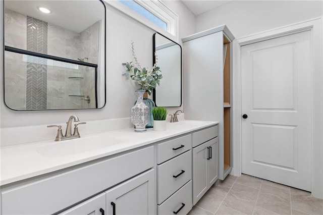 full bathroom with double vanity, a shower stall, and a sink