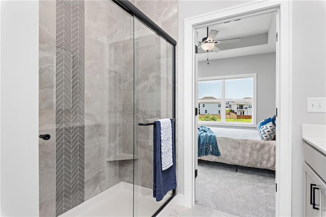 ensuite bathroom featuring vanity, connected bathroom, ceiling fan, and a shower stall