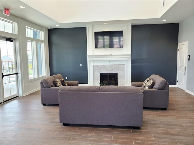 living room featuring recessed lighting, a brick fireplace, and wood finished floors