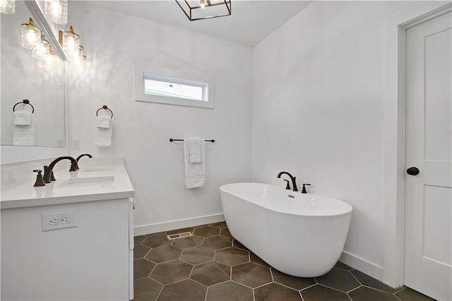 full bath with a soaking tub, baseboards, vanity, and tile patterned flooring