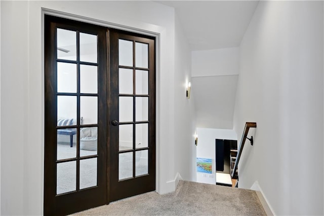 entryway featuring french doors, carpet, and baseboards