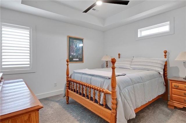 bedroom with carpet, a raised ceiling, a ceiling fan, and baseboards