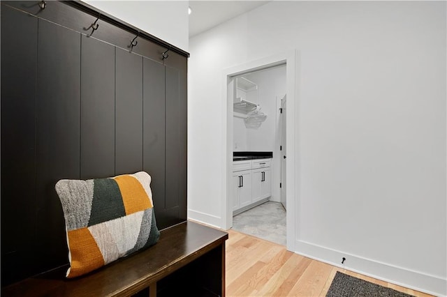 mudroom featuring light wood finished floors and baseboards